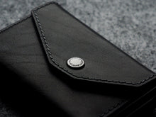 Load image into Gallery viewer, Close up to the front panel of the black wallet. 
