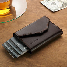 Load image into Gallery viewer, A brown leather wallet on a wooden table with six credit cards peeking from the side. 
