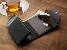 Load image into Gallery viewer, Interior view of the brown wallet with change tucked inside the compartments. 
