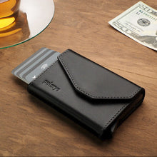 Load image into Gallery viewer, Front view of the black wallet arranged with credit cards, a tea cup and a bill. 
