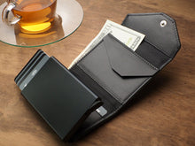 Load image into Gallery viewer, Interior view of the wallet with cash and credit cards arranged in the compartments. 
