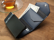 Load image into Gallery viewer, Interior view of the navy wallet with credit cards and cash arranged in the compartments. 
