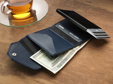 Load image into Gallery viewer, Interior view of the wallet with credit cards and cash tucked in the compartments. 
