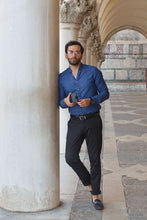 Load image into Gallery viewer, A young man holding his wallet in an urban setting. 
