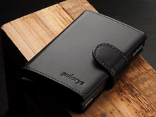 Load image into Gallery viewer, Angled view of the black wallet with pularys embossing. 
