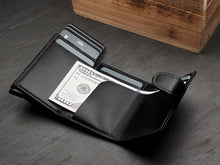 Load image into Gallery viewer, Interior view of the black wallet with a $100 bill and credit cards tucked into the compartments. 
