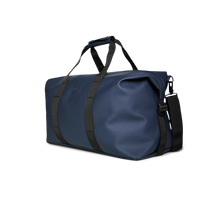 Load image into Gallery viewer, Angled front panel view of the blue duffle bag. 
