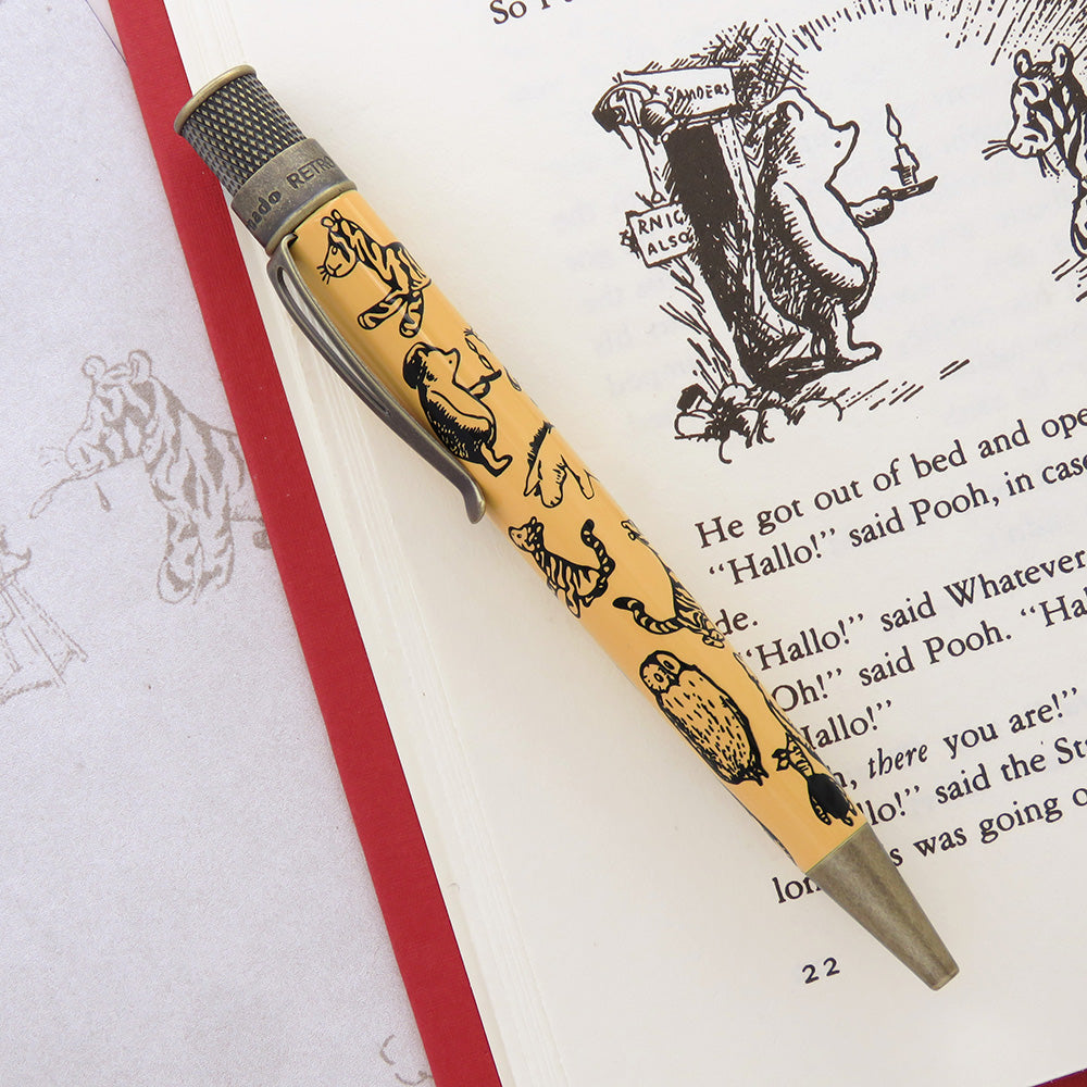 The pen featuring E.H. Shepard's classic black line art illustrations of beloved animal characters on a honey-colored barrel with antique brass accents.