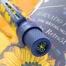 Load image into Gallery viewer, Close up to the top of the pen, set on top of the gift tube. A drawing of a flower is placed on the disk. 
