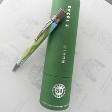Load image into Gallery viewer, The pen sits on top the green presentation tube with a white background.
