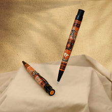 Load image into Gallery viewer, Two decorative pens with an orange, black, and brown pattern, displayed on draped cream fabric against a textured beige background.
