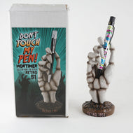Front view of Mortimer's hand with the original packaging, holding a Creepy Scrawler's pen. 