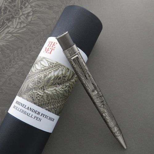 The rollerball pen leaning on the gift tube. 