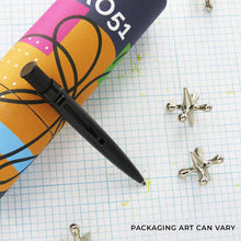 Load image into Gallery viewer, Black Stealth ballpoint on a grid surface with decorative objects around it, and packaging.
