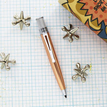 Load image into Gallery viewer, Copper ballpoint with decorative elements s on a grid background.
