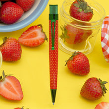 Load image into Gallery viewer, The Strawberry pen arranged on a yellow background with freshly cut strawberries and bowls.
