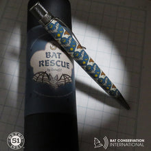 Load image into Gallery viewer, The pen with a bat themed print leaning on its presentation gift tube. 

