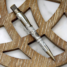 Load image into Gallery viewer, The pen with intricate geometric design, resting diagonally on a decorative wooden surface with a white marble background.
