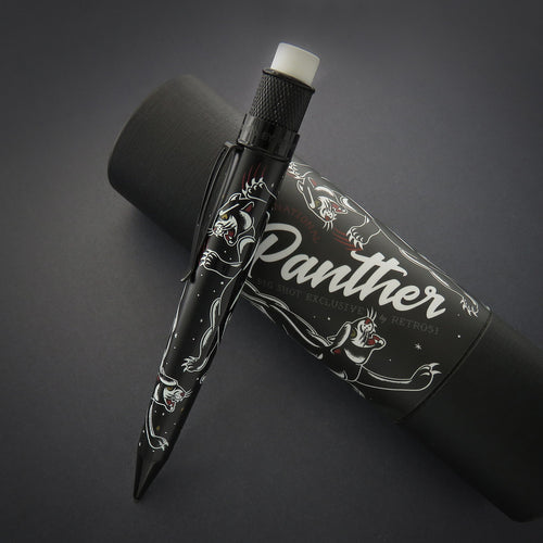 The black mechanical pencil with vintage panther tattoo graphics leaning on the gift packaging. 