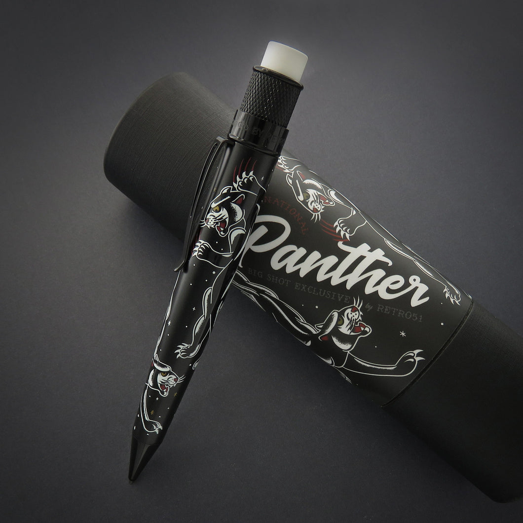 The black mechanical pencil with vintage panther tattoo graphics leaning on the gift packaging. 