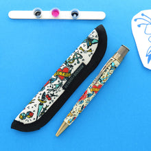 Load image into Gallery viewer, The rollerball and matching Rickshaw sleeve placed on a blue background. 
