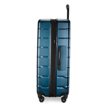 Load image into Gallery viewer, Side panel view of the navy blue suitcase with black accents. 
