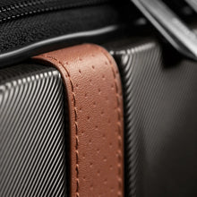 Load image into Gallery viewer, Close up to a tan leather strap attached to the suitcase. 
