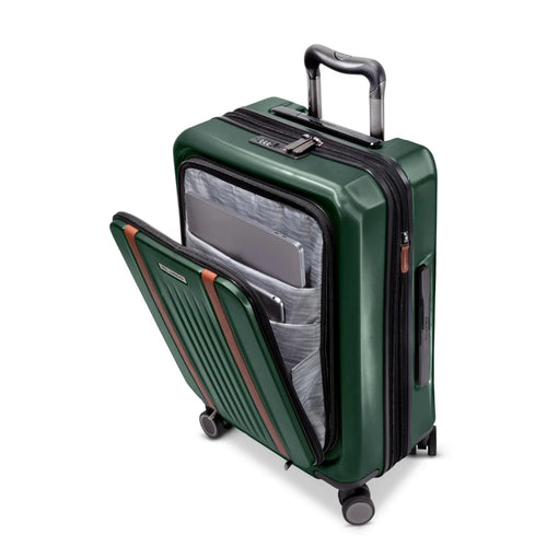 Angled front panel view of a green hard shell suitcase with the front pocket unzipped. It has a laptop and tablet compartment. 