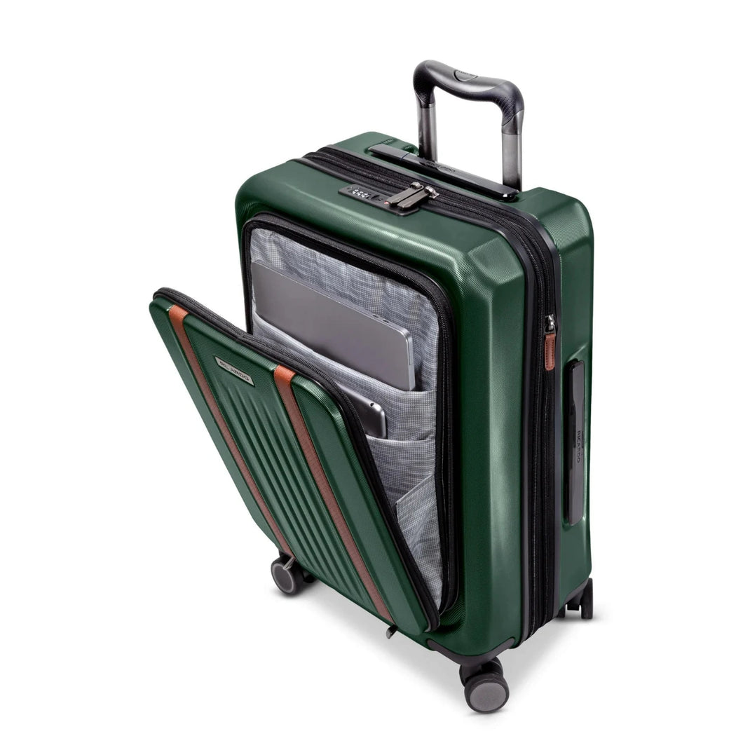 Angled front panel view of a green hard shell suitcase with the front pocket unzipped. It has a laptop and tablet compartment. 