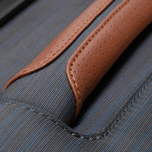 Load image into Gallery viewer, Close up to a fabric grab handle covered in a leather piece. 
