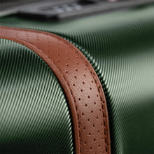 Load image into Gallery viewer, Close up to a tan leather strap on the suitcase. 
