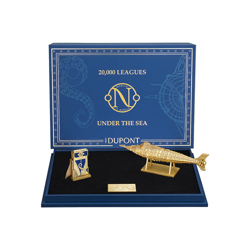 Gold colored submarine-shaped figure and a lighter, arranged in a '20,000 Leagues Under the Sea' themed display box.