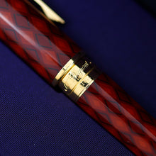 Load image into Gallery viewer, A close-up of the ring of the pen, engraved with the brand name 'S.T. Dupont', resting on a textured purple surface.
