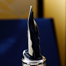 Load image into Gallery viewer, Angled close up to the back fountain pen nib on a blurred background. 
