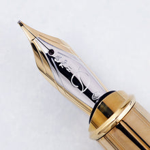Load image into Gallery viewer, Front close up to the fountain pen nib, engraved with decorations, 18K, 750, M, a cursive letter D, and a hallmark. 

