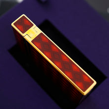 Load image into Gallery viewer, A side view of the lighter, resting diagonally on a dark purple presentation box.
