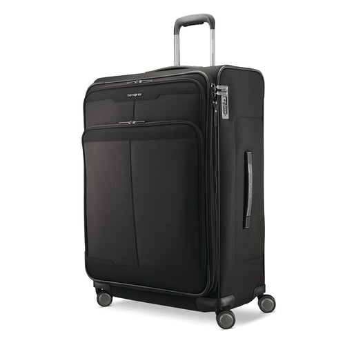 Angled front panel view of the large black spinner suitcase. 