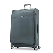 Load image into Gallery viewer, Angled front view of the slate blue suitcase with the telescopic handle partly extended. 
