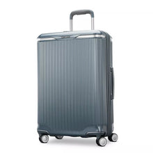 Load image into Gallery viewer, Angled front panel view of the slate blue suitcase. 
