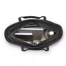 Load image into Gallery viewer, Top view of the tote bag with the main compartment unzipped, and filled with accessories. 
