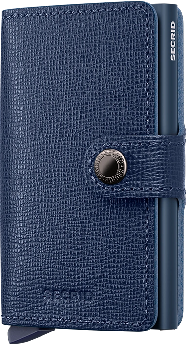 Angled front view of the navy blue mini wallet. A button closing strap is featured. 