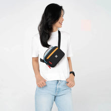 Load image into Gallery viewer, A young woman carrying the bag as a sling bag. 
