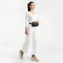 Load image into Gallery viewer, A young woman wearing a white outfit carrying the hip pack. 
