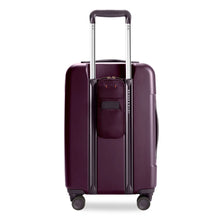 Load image into Gallery viewer, Back view of the plum colored hard shell suitcase. The telescopic handle is extended. An ID-tag on this side can be used to write your name and contact information A Power Pocket is available to store a power supply battery to charge items on the go.
