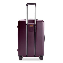 Load image into Gallery viewer, Back view of the plum colored hard shell suitcase. The telescopic handle is extended. An ID-tag on this side can be used to write your name and contact information. 
