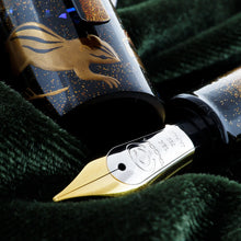 Load image into Gallery viewer, Close up to the cap and the fountain pen&#39;s nib. The nib is two-toned with an engraving of the Taccia logo, and the text 18K 750 Japan.
