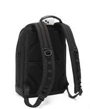 Load image into Gallery viewer, Angled back panel view of the backpack showing a cellphone peeking from its compartment under the top&#39;s grab handle.
