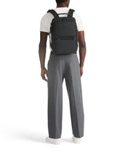 Load image into Gallery viewer, Back view of a young man carrying the backpack on his shoulders. 
