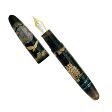 Load image into Gallery viewer, A fountain pen shown open with the cap beside it on a plain white background. The pen body and cap are dark green with gold-toned owl and landscape-style illustrations.
