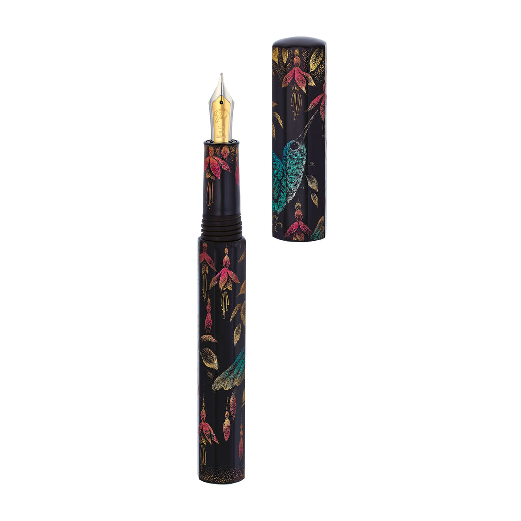 The Hummingbird fountain pen with the cap set to the side, showing the two-toned 18 carat gold nib. The grip section also has chinkin flowers which match the ones on the pen. 